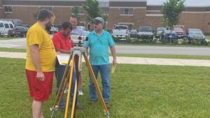 construction teachers receiving instruction on operating surveying equipment